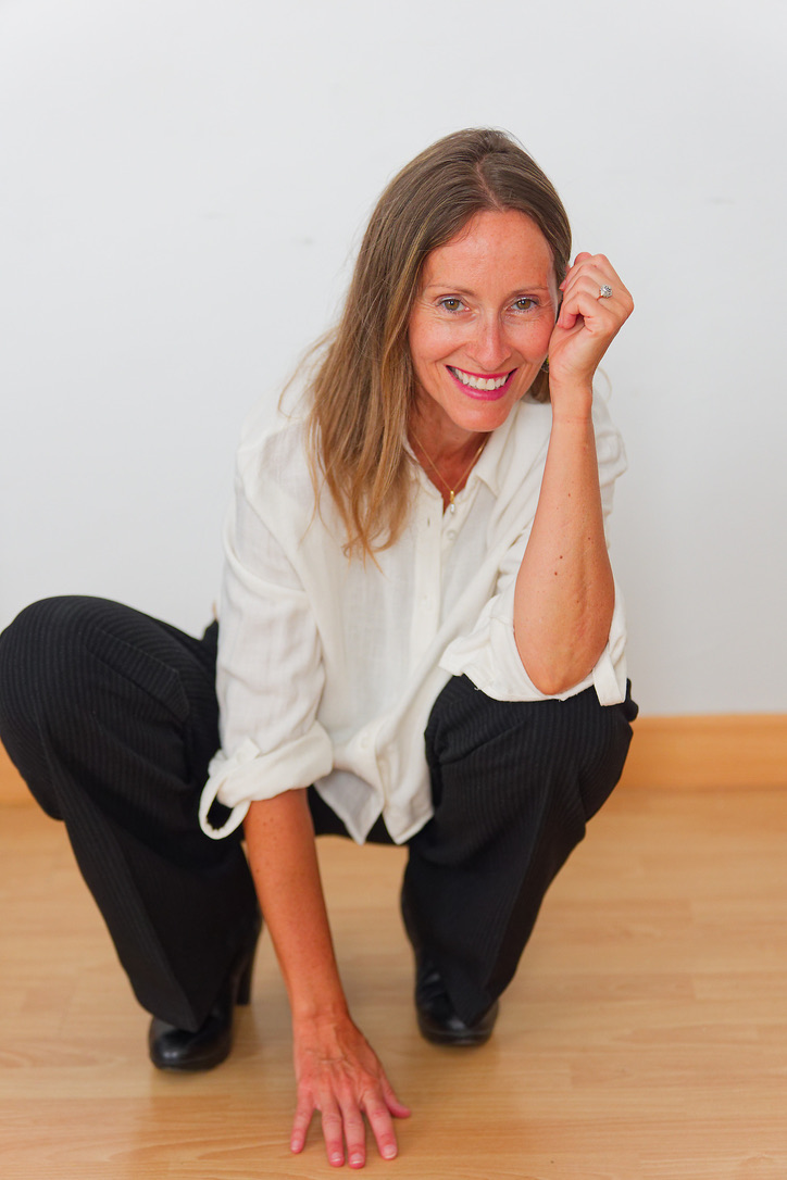 Karine Gorecki, posture entière, accroupie sur un plancher de bois